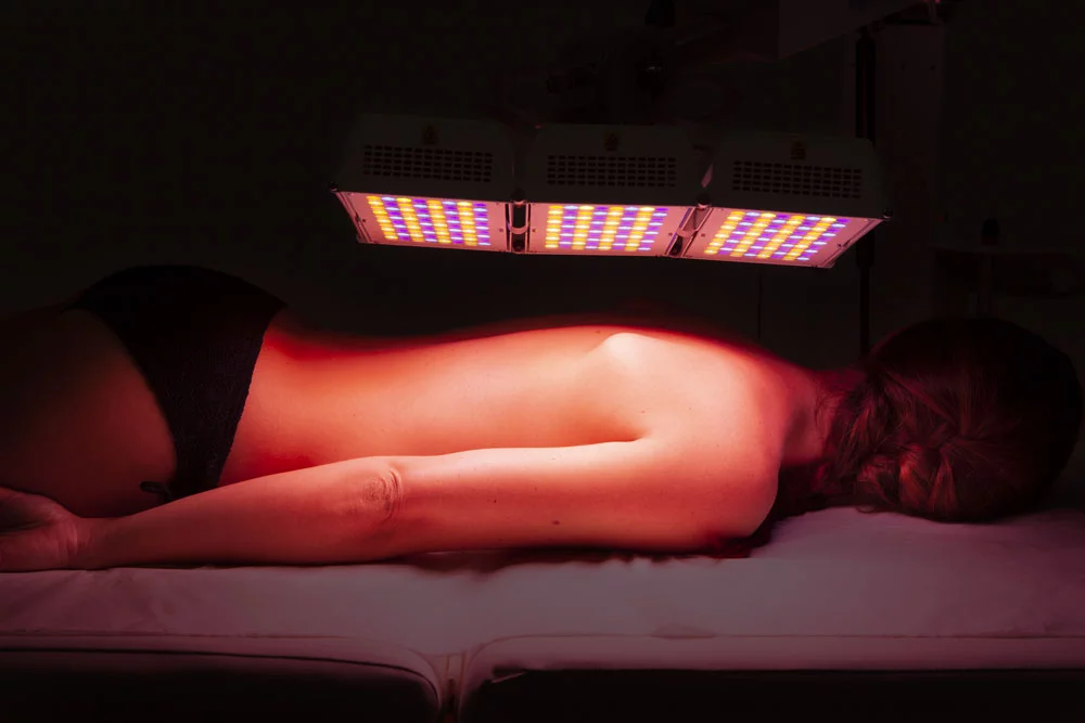 Séance de photobiomodulation LED du corps, panneau EsthéLED placé au-dessus des jambes d’une personne allongée.